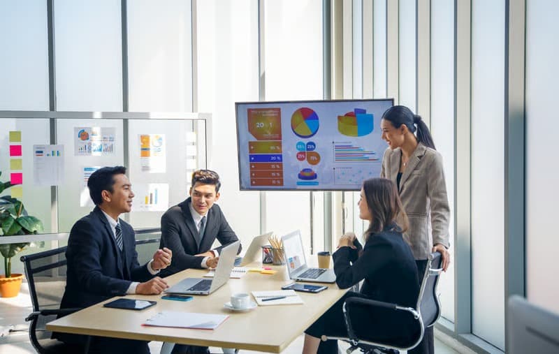 A team reviewing reporting dashboards together in a meeting room